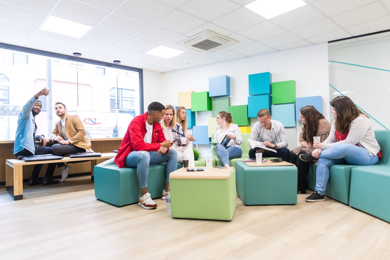 Students focused on laptop work in a shared learning space
