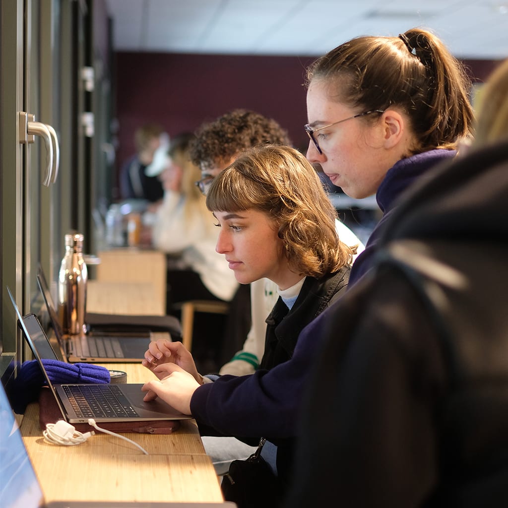 Two students working together on a laptop