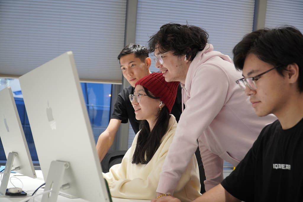 Students collaborating at desktop computers